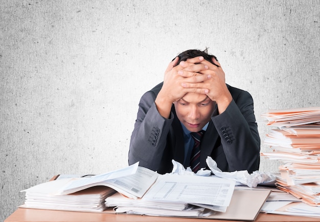 Surprised young businessman with stack of papers