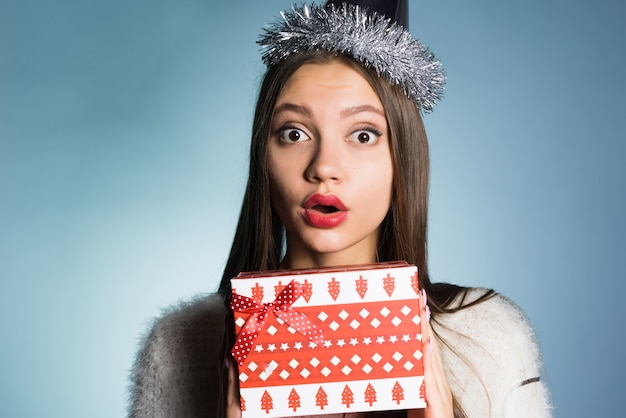 Photo surprised young girl received a gift for the new year from colleagues