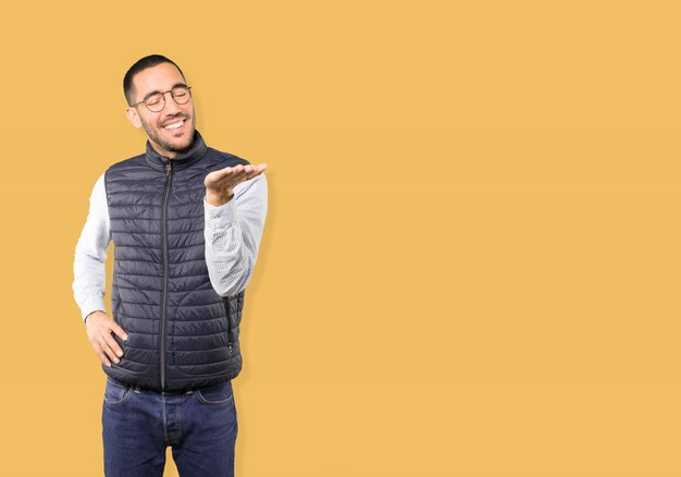 Photo surprised young man holding something with his hand