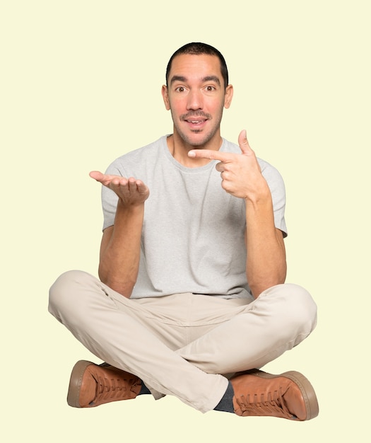 Surprised young man holding something with his hand