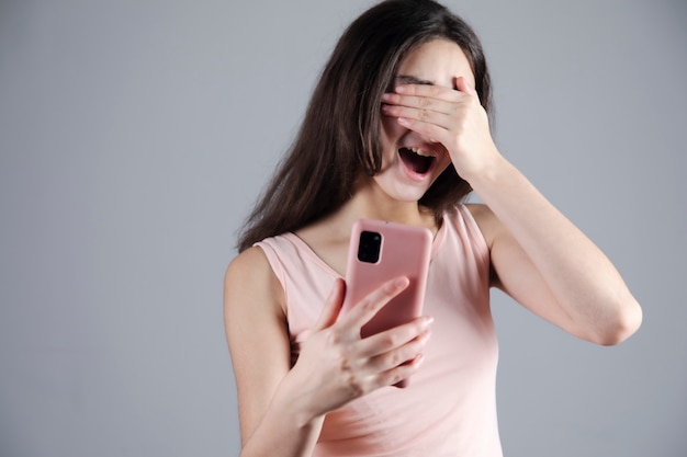 Удивленная молодая женщина с закрытыми глазами рука телефон