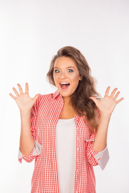 Surprised young woman picking her hands up