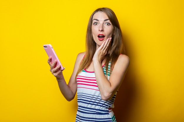 Surprised young woman in a striped dress