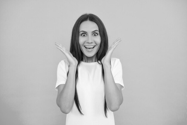 Photo surprised young woman in white shirt on blue background