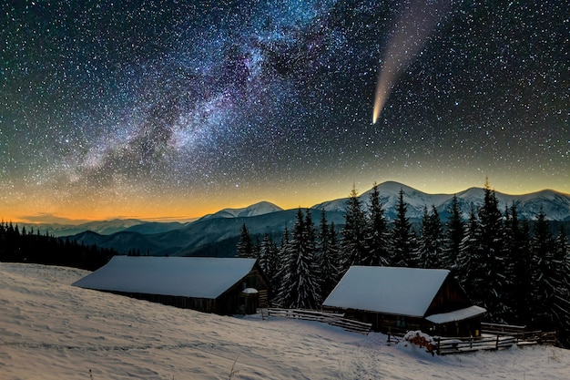 별이 빛나는 진한 파란색 흐린 하늘과 밝은 꼬리가있는 C / 2020 F3 (neowise) 혜성이있는 산에서 밤의 초현실적 인 전망.