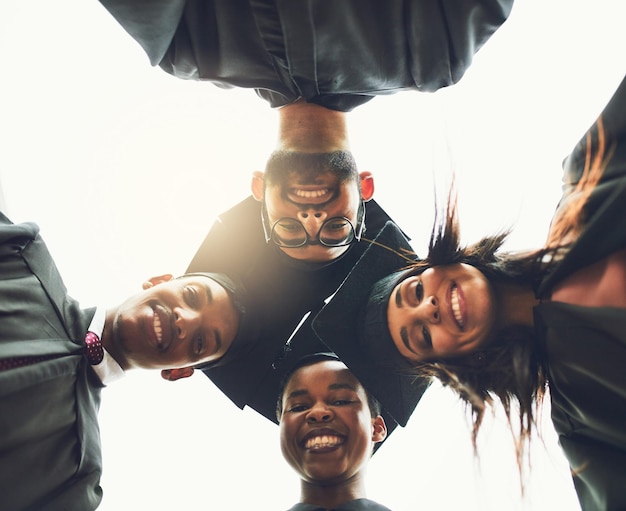 Photo surround yourself with the dreamers and the doers low angle shot of a group of fellow students standing together on graduation day