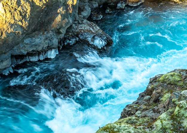 Окружающий вид вокруг водопада Храунфоссар необычная красивая природная достопримечательность Исландии