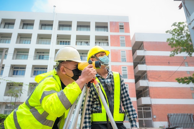 Survey team civil engineer are working using survey telescope at the construction site. use of survey telescope for construction work at construction sites. civil engineer using telescope at survey