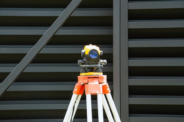 Photo surveying measuring equipment level transit on tripod at construction building area site