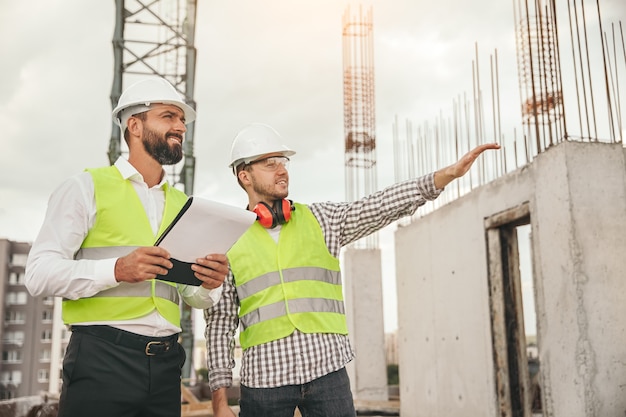 Surveyor and engineer inspecting construction site