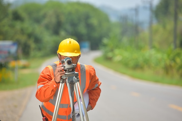 写真 道路工事でセオドライトを使用して測定を行う測量技師。建設現場の測量技師。