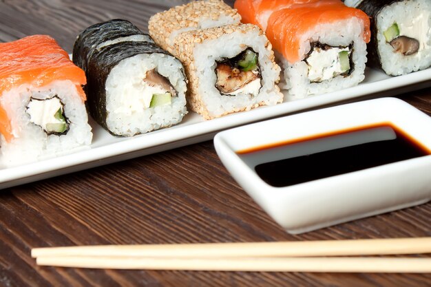 Sushi-assortiment op witte schotel op bruine houten tafel