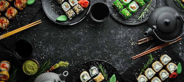 Sushi bar menu Set of colored delicious sushi rolls on black plates Top view