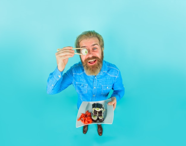 Sushi bearded man with sushi near face japan hipster eating sushi sushi delivery japanese food