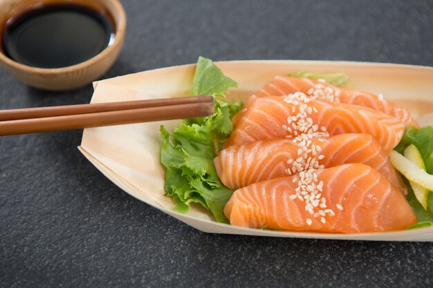 Sushi on boat shaped plate with chopsticks