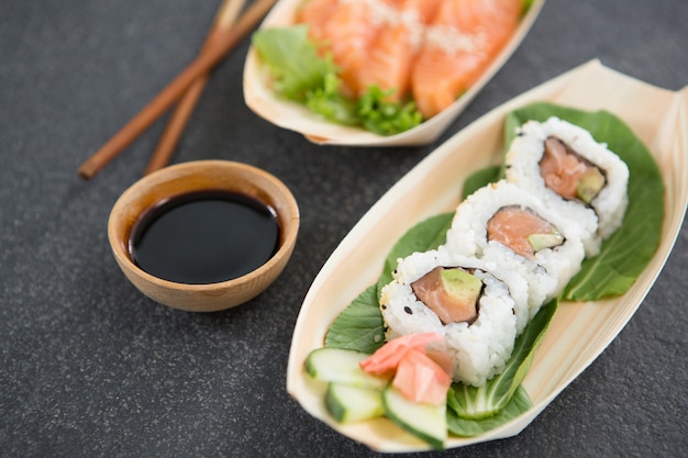 Sushi on boat shaped plate with chopsticks