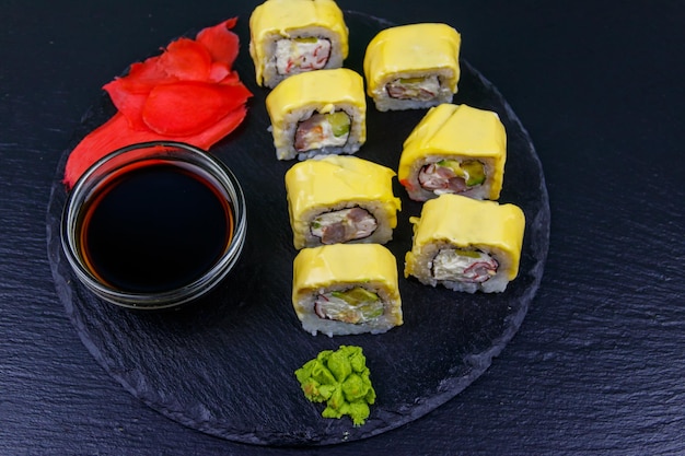 Sushi cheese rolls on a black slate