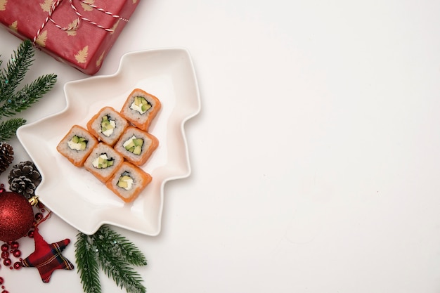 クリスマスコンセプトの寿司。白のフィラデルフィアロールから作られた食用のクリスマスツリー