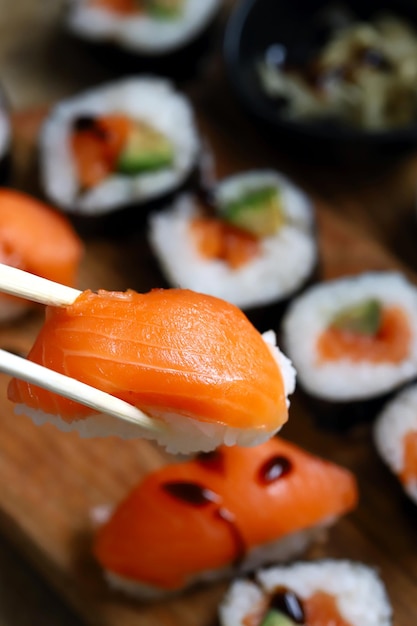 Sushi en broodjes met avocado en zalm op een houten bord