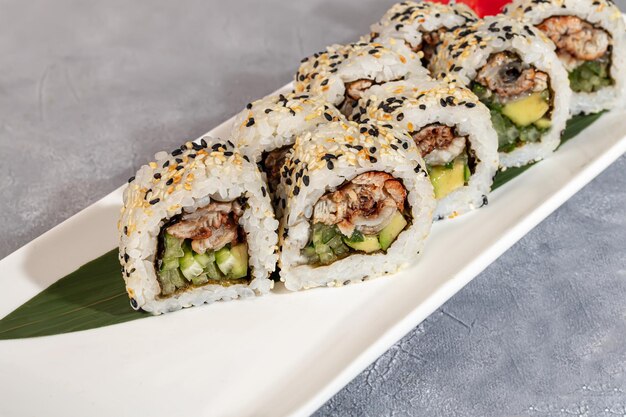 Sushi en broodjes met kaviaar garnalen en tonijn avocado op een grijze achtergrond Kopieer ruimte