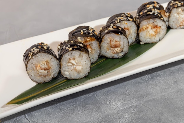 Foto sushi en broodjes met kaviaar garnalen en tonijn avocado op een grijze achtergrond kopieer ruimte