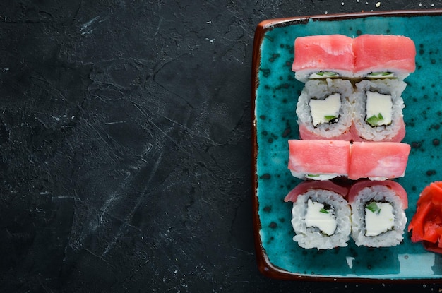 Sushi en broodjes op het bord Bovenaanzicht Vrije ruimte voor uw tekst Op een zwarte achtergrond