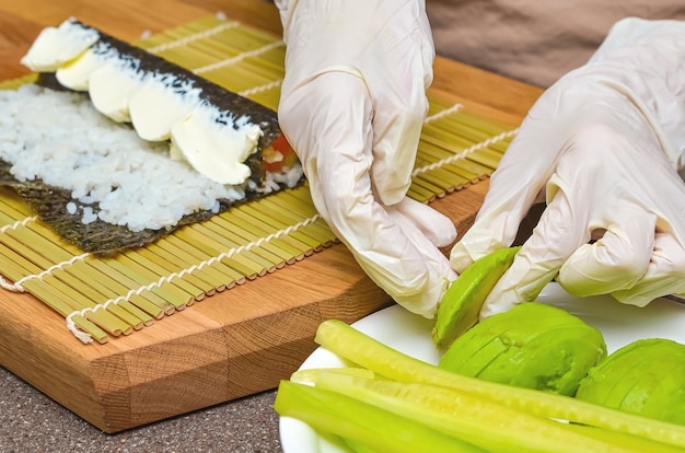 Sushi en broodjes voorbereidingsproces, bovenaanzicht, avocado voor Japanse sushi.