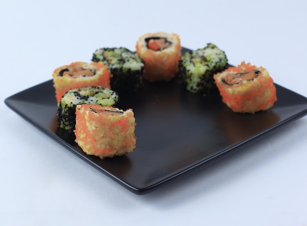 Sushi en rolls de set wordt geserveerd op een zwart bord