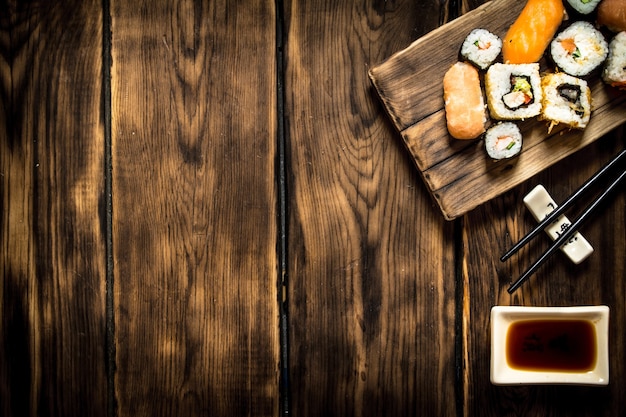 Sushi en rolt zeevruchten met sojasaus. op houten achtergrond.