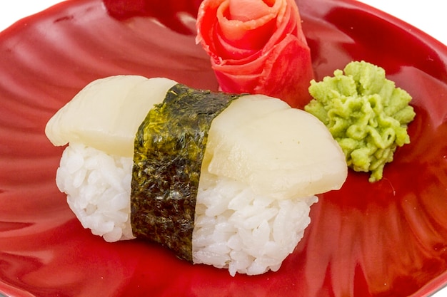 Суши хотатэ с ломтиком морского гребешка на белом фоне