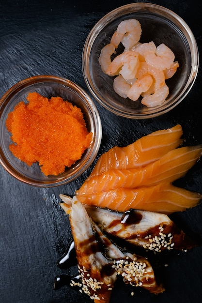 暗い背景に寿司の食材。鮭うなぎのエビキャビア。国民のアジア料理