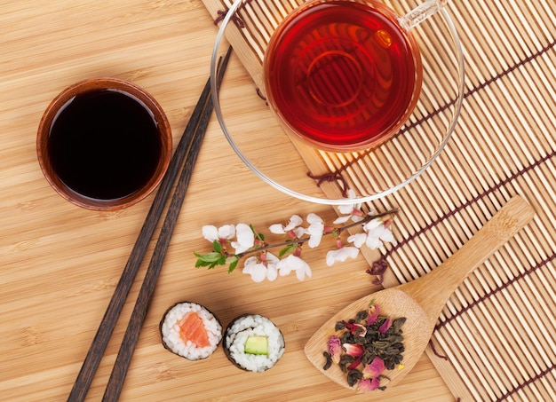 Sushi maki set herbal tea and sakura branch