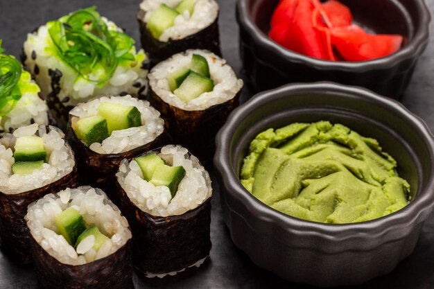 Sushi met komkommer en zeewier Wasabi in een zwarte kom