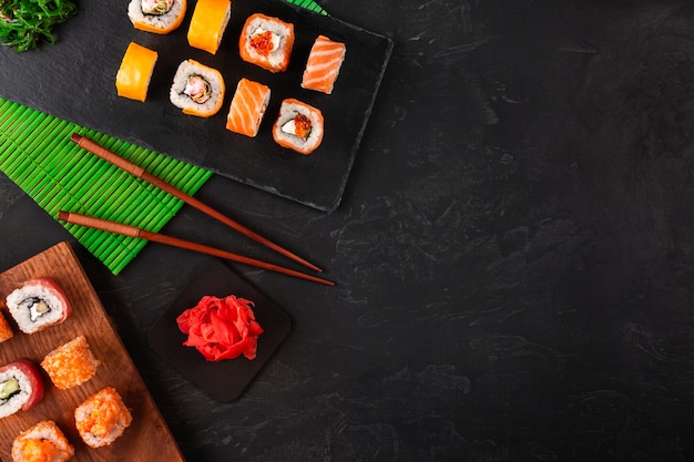 Sushi met wasabi en gember op zwarte stenen lade op zwarte tafel. Bovenaanzicht