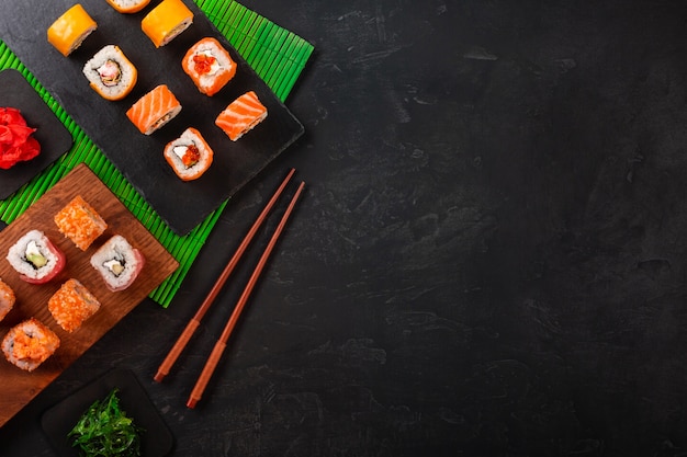 Sushi met wasabi en gember op zwarte stenen lade op zwarte tafel. Bovenaanzicht