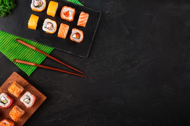 Sushi met wasabi en gember op zwarte stenen lade op zwarte tafel. Bovenaanzicht