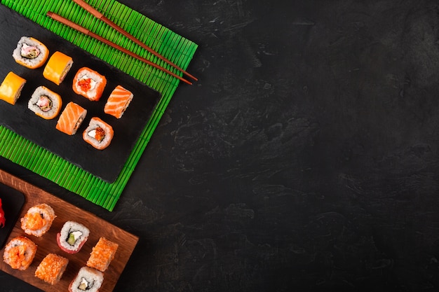 Sushi met wasabi en gember op zwarte stenen lade op zwarte tafel. bovenaanzicht