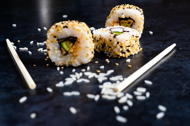 Sushi op een zwarte tafelplaat met houten eetstokjes Japans eten in restaurant