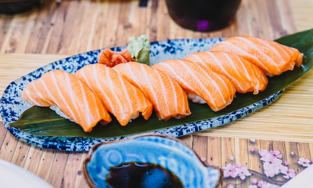 Sushi plate consisting of salmon nigiri with soy sauce served on a terrace