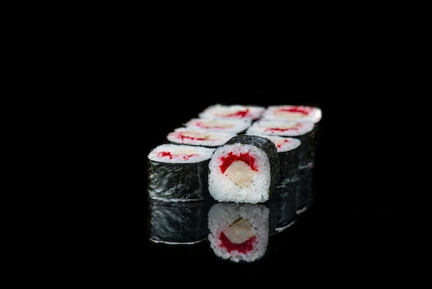 Sushi roll on a black background reflection  japanese food close up