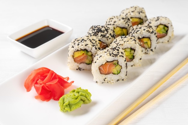 Foto sushi roll california met zalm sesamzaad avocado roomkaas op witte achtergrond sushi