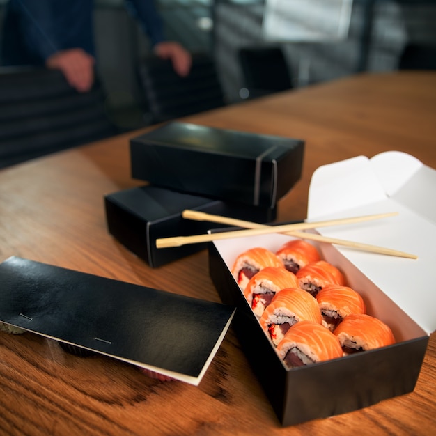 写真 箸で作業スペースにある巻き寿司配達ボックス。オフィスランチ