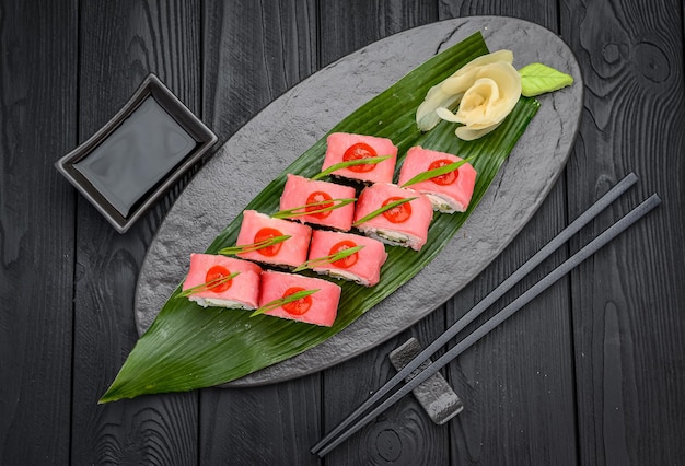 Sushi roll draak met tonijn Traditionele heerlijke verse sushi roll set op een zwarte achtergrond Sushi menu Japanse keuken restaurant Aziatisch eten