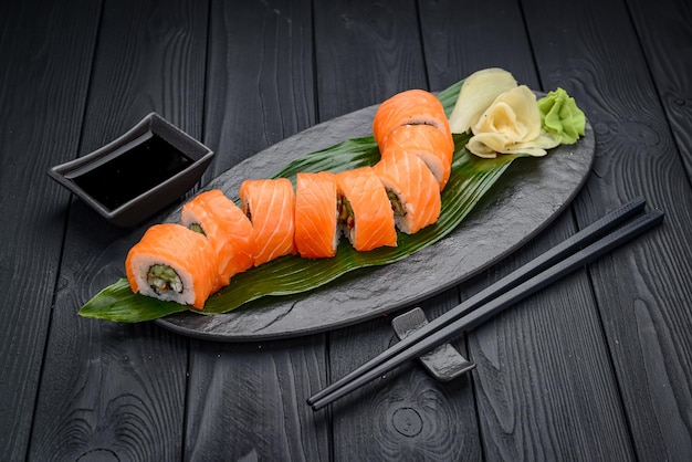 Sushi roll dragon with smoked eel and salmon Traditional delicious fresh sushi roll set on a black background Sushi menu Japanese kitchen restaurant Asian food