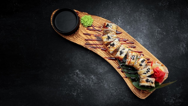 Sushi roll Golden dragon with eel salmon tobiko and cream cheese on a wooden board