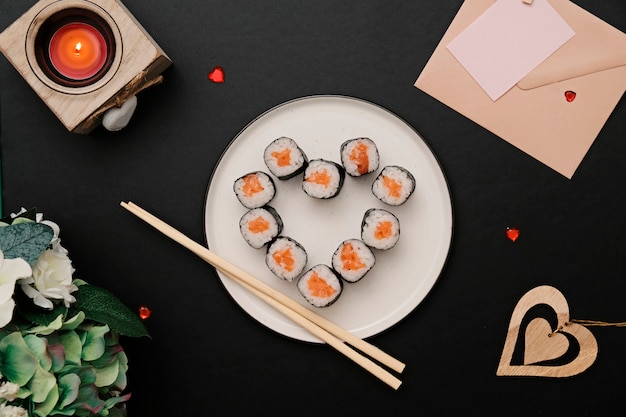 Sushi roll in heart shape, on plate. Flat lay.