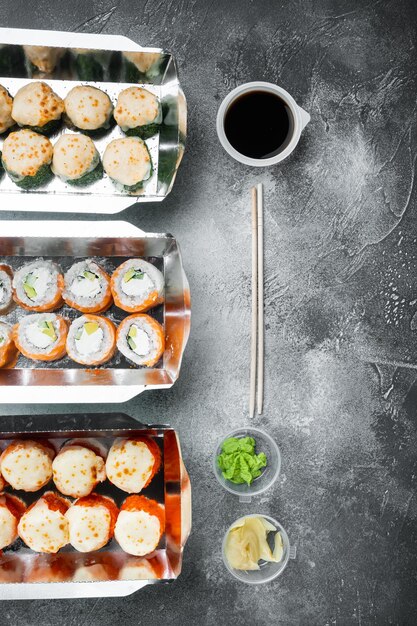Sushi roll levering set, op grijze stenen achtergrond, bovenaanzicht plat lag, met copyspace en ruimte voor tekst