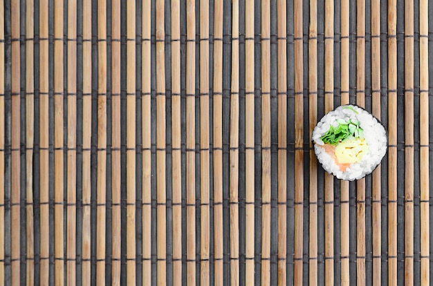 Photo sushi roll lie on a bamboo straw serwing mat