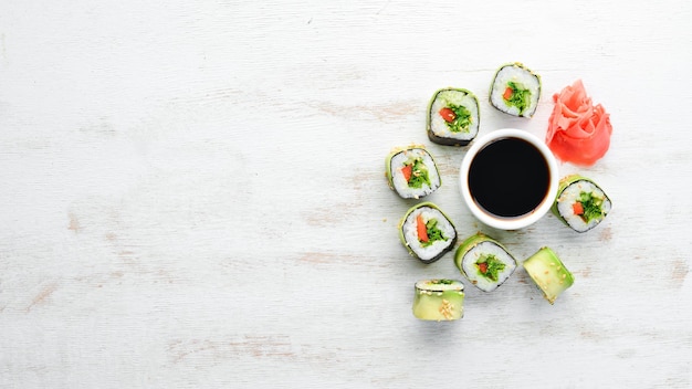 Sushi roll met avocado, komkommer en tomaat Japanse keuken Bovenaanzicht op een witte houten achtergrond