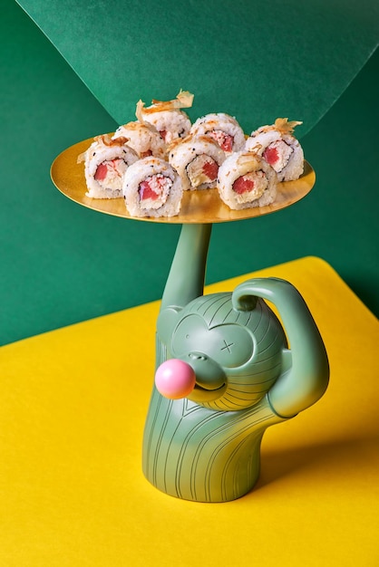 Sushi roll met tonijn garnaal zalm gerookte paling avocado philadelphia kaas op een gele achtergrond